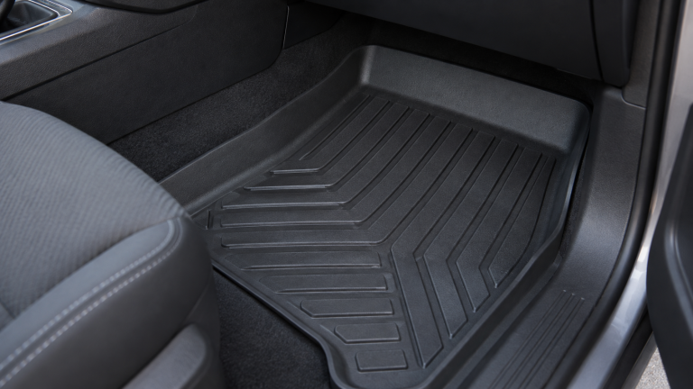 Textured floor liner with a raised edge in a passenger footwell