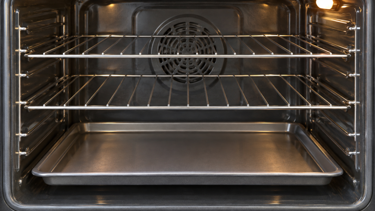 Oven interior with metal racks and a baking tray